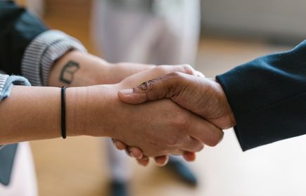 Zwei Personen geben sich die Hand